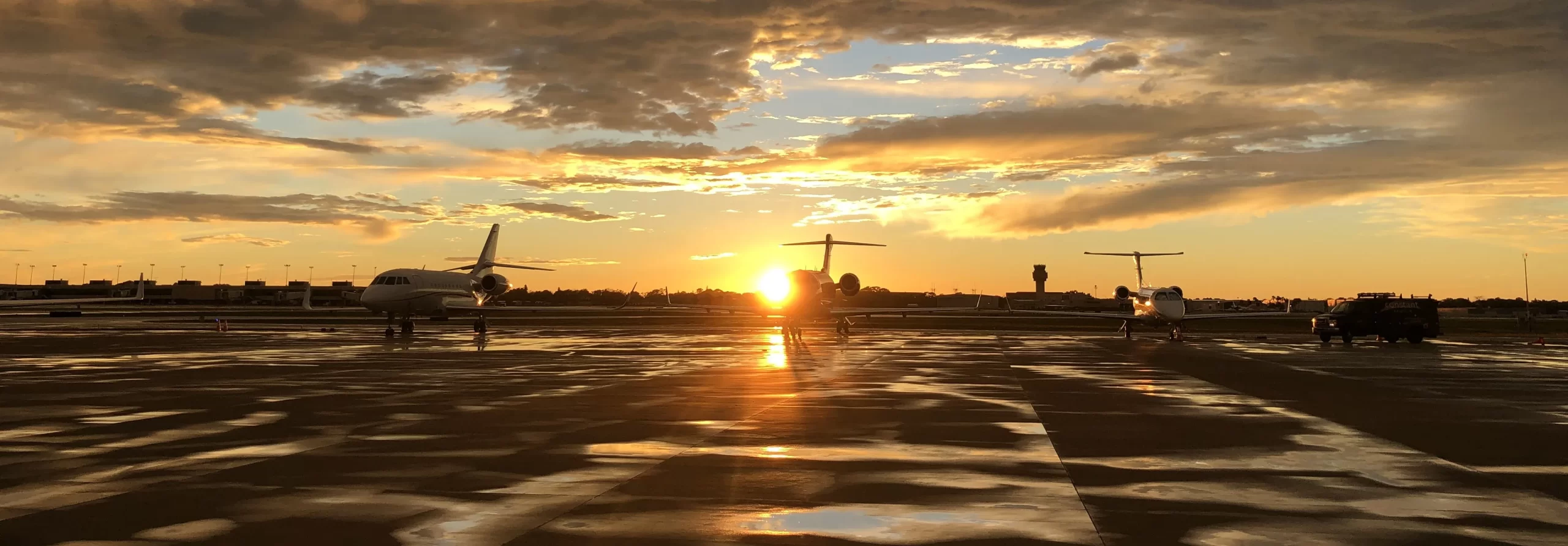 Parked planes in front of sunset at CAA FBO